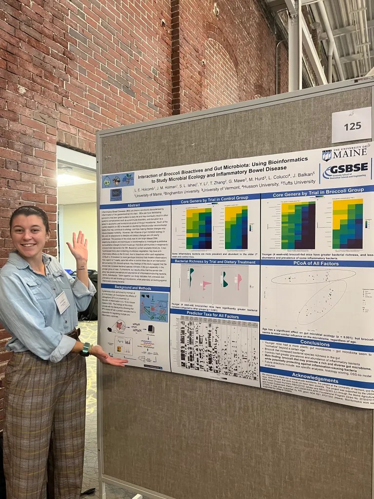 Lola standing in front of her poster which displays the results of her research on gut microbes.