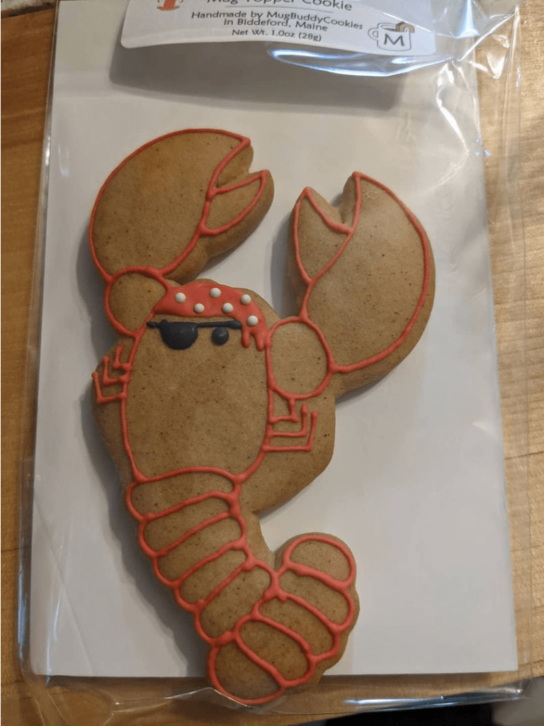 A cookie in the shape of a lobster with icing to make it look like a pirate.